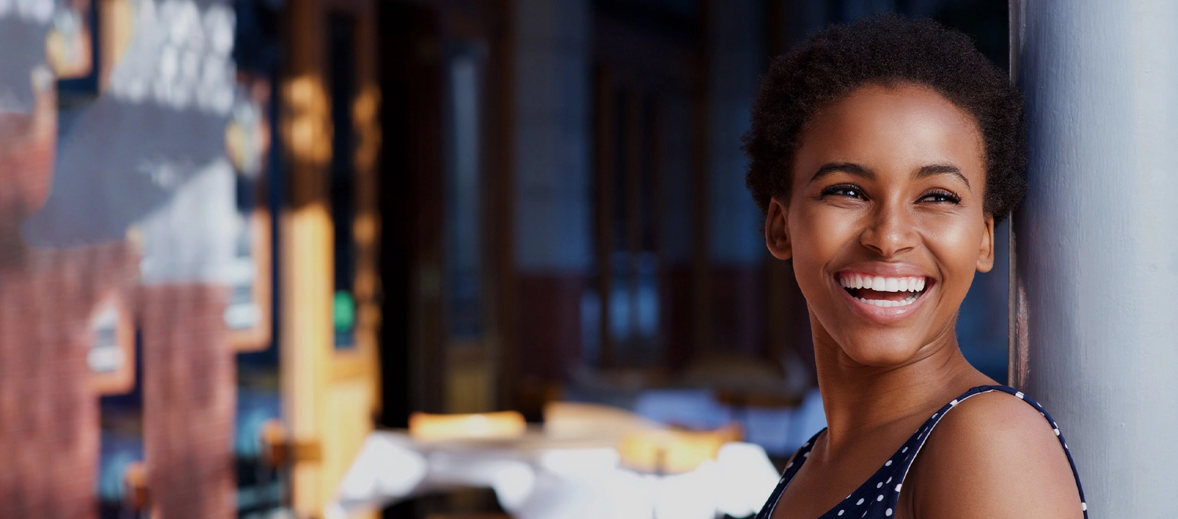 Smiling woman in professional dental office setting with blurred background