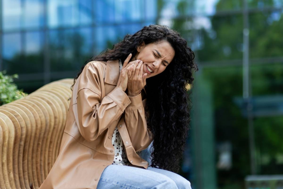 Woman smiling while on phone call, representing positive patient communication about dental care.